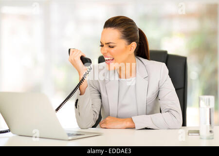 wütende junge Geschäftsfrau schreien am Telefon im Büro Stockfoto