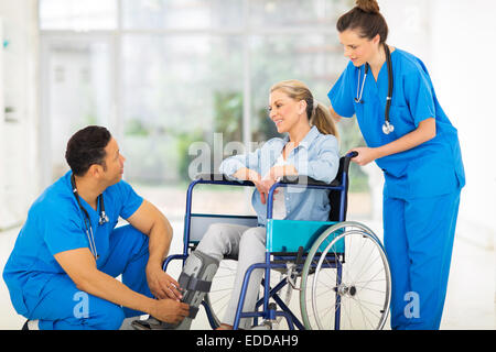 freundlicher Arzt im Gespräch mit einer sich erholenden Patienten im Rollstuhl Stockfoto