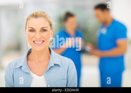 lächelnd Mitte für Untersuchung in Arztpraxis wartende Frau im Alter von Stockfoto
