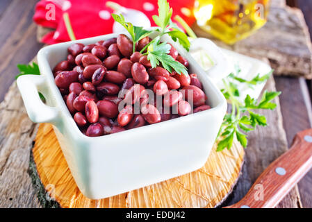 rote Bohnen in die Schüssel geben und auf einem Tisch Stockfoto