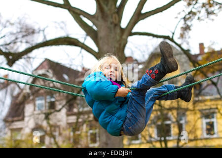 Kleines Mädchen Klettern auf Spielgeräten Stockfoto