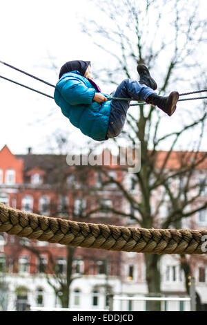 Kleines Mädchen Klettern auf Spielgeräten Stockfoto