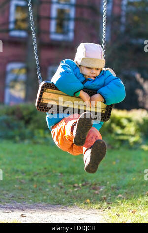 Kleines Mädchen auf einer Schaukel hängen Stockfoto