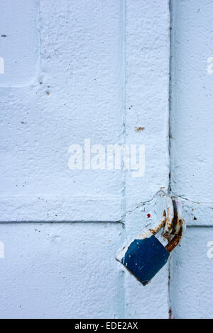 Blaues Vorhängeschloss an einer blauen Metalltür Stockfoto