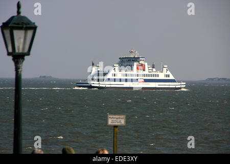 Eine Fähre geht zu den kleinen Inseln in der Nordsee vor Wyk auf Föhr. Die Strandpromenade von Wyk verläuft parallel entlang des Strandes. Foto: Klaus Nowottnick Datum: 20. April 2014 Stockfoto