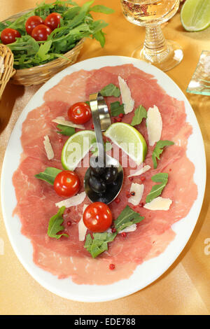eine Platte mit Carpaccio, Oliven und Rucola Stockfoto