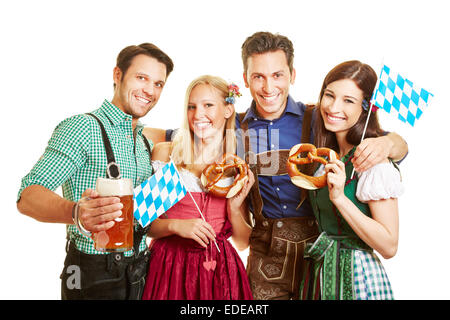 Gruppe der happy Friends feiert Oktoberfest mit Bier und Brezel in Bayern Stockfoto