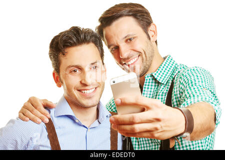 Zwei lächelnde Freunde in Baviara, wobei ein Selbstporträt mit ihrem smartphone Stockfoto