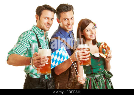 Drei Freunde im bayerischen Outfit trinken Bier auf dem Oktoberfest in Bayern Stockfoto