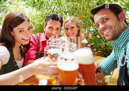 Lächelnden Freunde in ihre Gläser klirren, im Sommer Biergarten Stockfoto