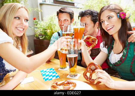 Zwei glückliche Frauen Klirren Biergläser draußen im Sommer Stockfoto