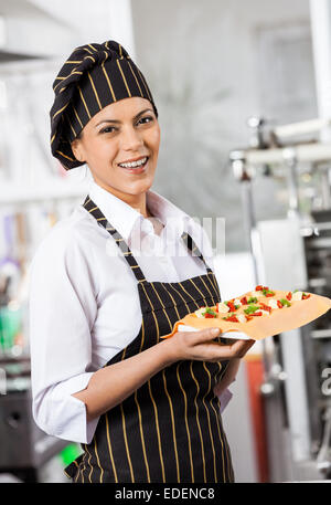 Happy Chef Holding Tablett mit gefüllte Teigwaren Blatt Stockfoto