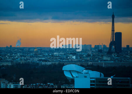 Der Eiffelturm in der Dämmerung und der Tour Maine-Montparnasse (Maine-Montparnasse-Turm). Auch allgemein benannt Tour Montparnasse, es ist ein 210 m (689 ft) Büro-Hochhaus befindet sich in Montparnasse Paris, Frankreich. Es wurde von 1969 bis 1973 gebaut. Leider ist es ein Dorn im Auge das Stadtbild von Paris La Defense gesehen. Im Vordergrund steht die Louis Vuitton Foundation (zuvor Louis Vuitton Foundation für Erstellung, auf Französisch "Fondation Louis-Vuitton Pour la Création"). Seit 2006 ist es ein Museum für Kunst und Kulturzentrum gesponsert von der LVMH-Gruppe. Auf der linken Seite ist t Stockfoto