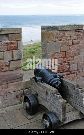 Canon auf Bamburgh Castle Burgwall.  Farne Islands hinaus. Stockfoto