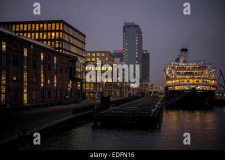 Kreuzfahrtschiff vor Anker am Terminal Amsterdam Passagiere in der Abenddämmerung mit Skyline der Stadt im Hintergrund Stockfoto