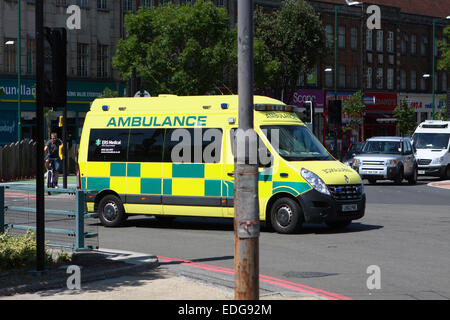 Ein Krankenwagen, um einen Kreisverkehr in Tolworth, Surrey, England reisen Stockfoto