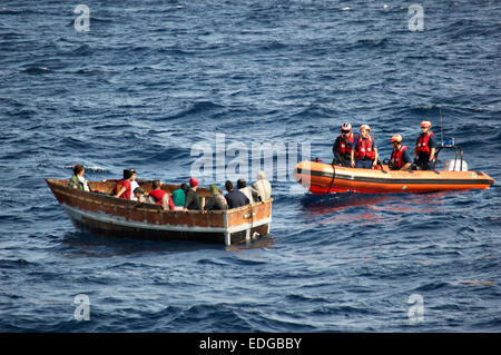 Mitglieder der uns Coast Guard Cutter Ritter Insel nähern ein Boot mit 12 kubanischen Migranten 30. Dezember 2014 südwestlich von Key West, Florida. Die U.S. Coast Guard-Berichte, die die Anzahl der Kubaner abgeholt am Meer versucht, den Vereinigten Staaten zu erreichen ist angestiegen, da Präsident Barack Obama angekündigt, diplomatische Beziehungen zu Havanna wiederherzustellen. Stockfoto