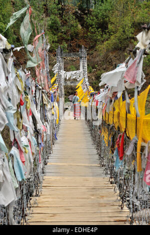 Fußgängerbrücke, gesäumt von Gebetsfahnen, Jakar, Bumthang, Bhutan Stockfoto