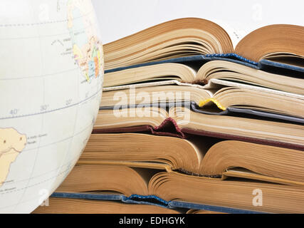 Stapel von offenen Bücher und Globe isoliert auf weißem Hintergrund Stockfoto