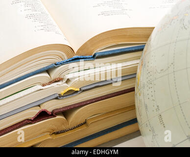 Stapel von offenen Bücher und Globe isoliert auf weißem Hintergrund Stockfoto