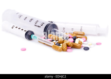Medizinische Spritzen, Tabletten und Kapseln, die isoliert auf weißem Hintergrund. Stockfoto