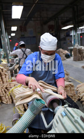 (150107)--LIPU (GUANGXI), 7. Januar 2015 (Xinhua)--Arbeiter verarbeiten Kleiderbügel in einer Fabrik in Lipu County, Südwest-China Autonome Region Guangxi Zhuang, 6. Januar 2015. Mit 126 Fabriken Herstellung von Kleiderbügeln erreicht die jährliche Ausgabe des Handels mit Lipu 6,5 Milliarden RMB Yuan (ca. 1,06 Milliarden US-Dollar). (Xinhua/Lu Bo'an) (wf) Stockfoto