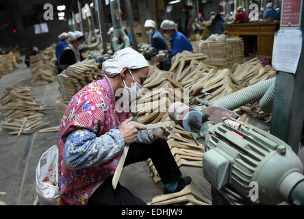 (150107)--LIPU (GUANGXI), 7. Januar 2015 (Xinhua)--Arbeiter verarbeiten Kleiderbügel in einer Fabrik in Lipu County, Südwest-China Autonome Region Guangxi Zhuang, 6. Januar 2015. Mit 126 Fabriken Herstellung von Kleiderbügeln erreicht die jährliche Ausgabe des Handels mit Lipu 6,5 Milliarden RMB Yuan (ca. 1,06 Milliarden US-Dollar). (Xinhua/Lu Bo'an) (wf) Stockfoto