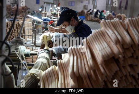 (150107)--LIPU (GUANGXI), 7. Januar 2015 (Xinhua)--Arbeiter verarbeiten Kleiderbügel in einer Fabrik in Lipu County, Südwest-China Autonome Region Guangxi Zhuang, 6. Januar 2015. Mit 126 Fabriken Herstellung von Kleiderbügeln erreicht die jährliche Ausgabe des Handels mit Lipu 6,5 Milliarden RMB Yuan (ca. 1,06 Milliarden US-Dollar). (Xinhua/Lu Bo'an) (wf) Stockfoto