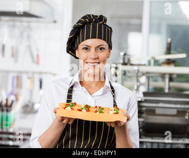 Porträt von Happy Chef Holding Tablett mit gefüllte Teigwaren Blatt Stockfoto