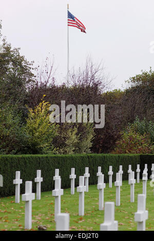 Amerikanische Flagge vor weißen Kreuze an Flanders Field, American Cemetery, Waregem, Belgien. Stockfoto