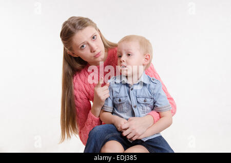 Junge schöne Mutter schimpft mit ihrem rebellischen und launisch drei Jahre alten Jungen Stockfoto