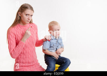 Junge schöne Mutter schimpft mit ihrem rebellischen und launisch drei Jahre alten Jungen Stockfoto