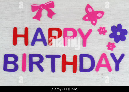 Happy Birthday geschrieben mit bunten Buchstaben auf weißem Holz Stockfoto