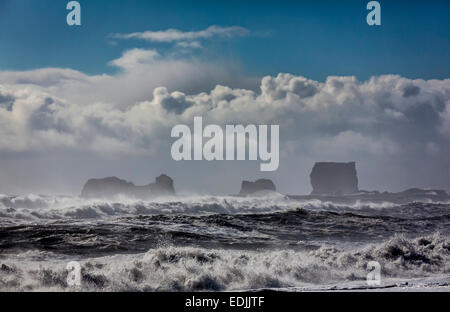 Wellen am Ufer mit Dryholaey im Hintergrund, Island. Dyrhólaey übersetzt bedeutet "Der Tür Loch Island" Stockfoto