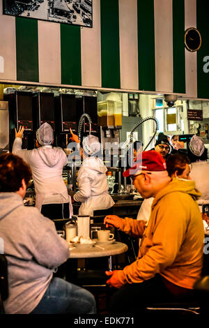 Leute sitzen genießen Kaffee und Krapfen in das Cafe du Monde, New Orleans LA Stockfoto