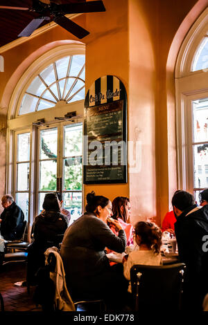 Leute sitzen genießen Kaffee und Krapfen in das Cafe du Monde, New Orleans LA Stockfoto