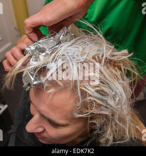 Eine Frau, die Highlights in ihr Haar setzen Stockfoto