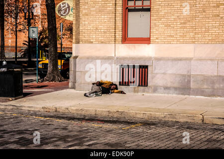 Schlafen auf dem Bürgersteig in einer ruhigen Straße in der Stadt New Orleans Louisiana Obdachlose Alkoholiker Stockfoto