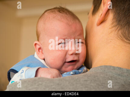 Ein zwei Monate altes Baby weint während er statt. Stockfoto