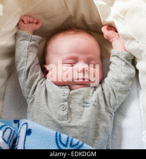 Ein drei Wochen altes Baby schläft in einem Körbchen. Stockfoto