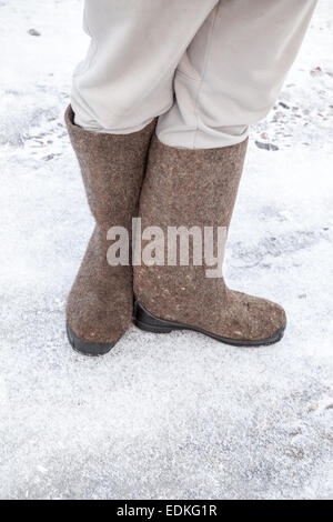 Füße mit traditionellen russischen fühlte Stiefel Winter mit Schnee und Eis unterwegs stehen Stockfoto