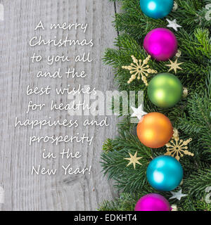 englische Weihnachtskarte mit Weihnachtskugeln, Tannenzweigen und "goldene Sterne" Stockfoto