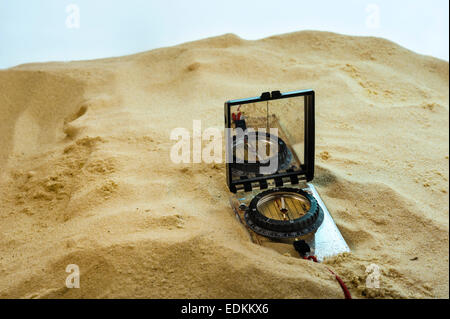 Kompass im Sand begraben. Stockfoto