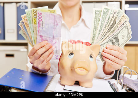 Hände einer Business-Frau mit US-Dollar und Euro Rechnungen in der Nähe ein Sparschwein Stockfoto