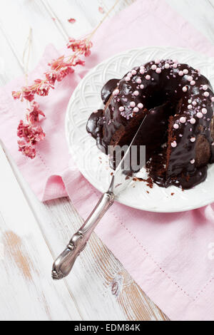 Schokoladen Gugelhupf mit rosa Verzierungen Stockfoto