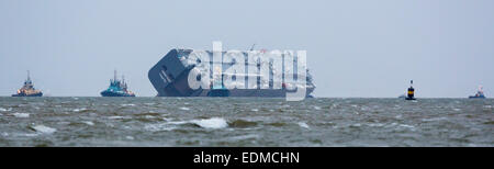 Da das Wetter verschlechtert und Dämmerung nähert sich schnell, wird der Fahrzeug Träger Hoegh Osaka von Bergung Schlepper gezogen. Stockfoto