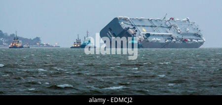 Da das Wetter verschlechtert und Dämmerung nähert sich schnell, wird der Fahrzeug Träger Hoegh Osaka von Bergung Schlepper gezogen. Stockfoto