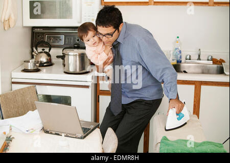 Vater Multitasking zu Hause Stockfoto