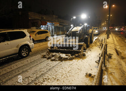 Jerusalem, Jerusalem, Palästina. 7. Januar 2015. Ein Bulldozer löscht eine Straße von Schnee in Jerusalem am 7. Januar 2015. Wie starke Winde der Region zerschlagen und Temperaturen auf Null gesunken, Israel Polizei geschlossen die beiden Hauptzufahrtsstraßen in Jerusalem mehrere Stunden, bevor der Schnee fallen begann © Muammar Awad/APA Bilder/ZUMA Draht/Alamy Live News Stockfoto