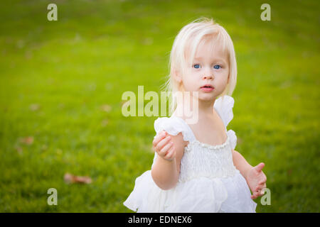 Schöne entzückende kleine Mädchen tragen weißes Kleid In einer Wiese. Stockfoto